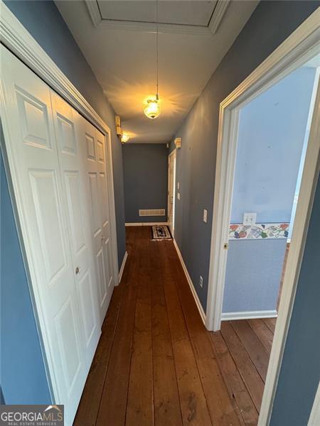 corridor with attic access, baseboards, and hardwood / wood-style floors