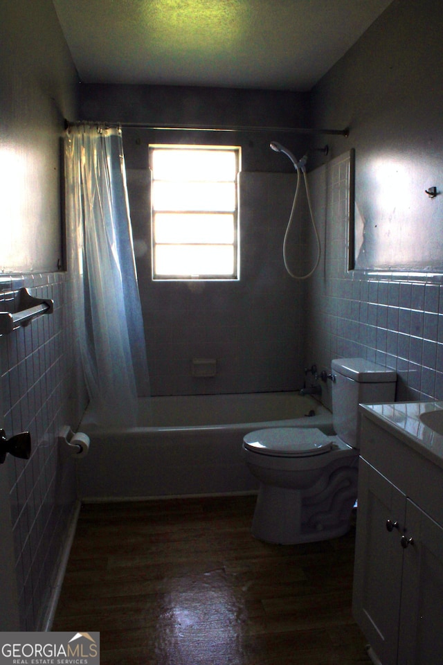 full bathroom featuring tile walls, toilet, shower / bathtub combination with curtain, and wood finished floors