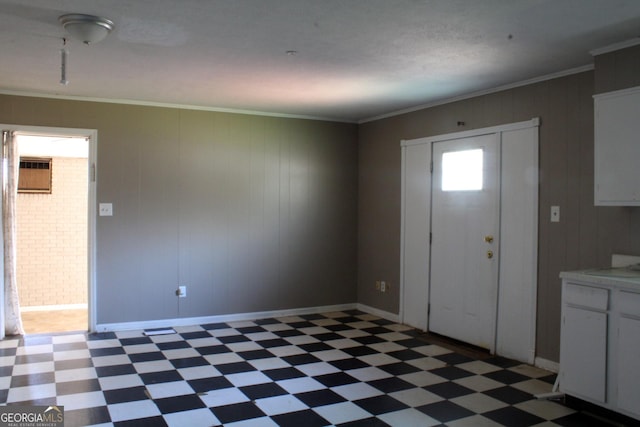 entrance foyer featuring baseboards, light floors, and crown molding