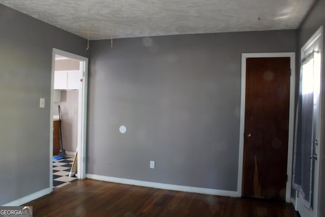 unfurnished bedroom with wood finished floors, baseboards, and a textured ceiling