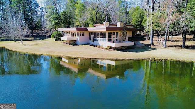 rear view of house with a water view and dirt driveway