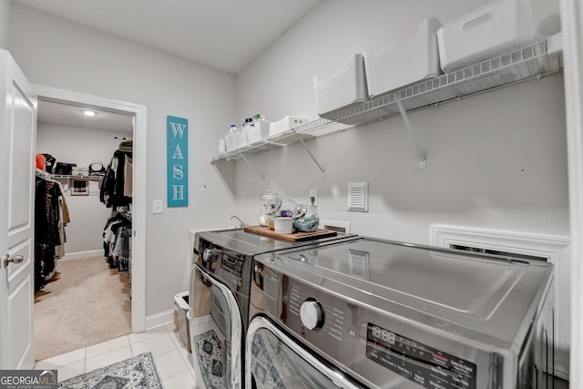 washroom with independent washer and dryer, light tile patterned floors, baseboards, light colored carpet, and laundry area