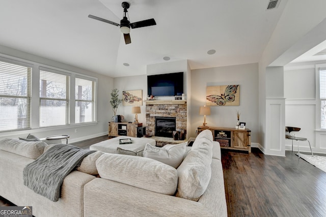 living room with visible vents, dark wood-type flooring, a fireplace, lofted ceiling, and ceiling fan