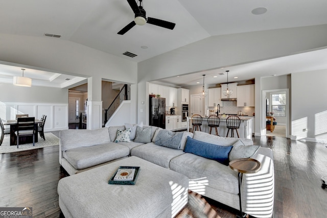 living area with vaulted ceiling, dark wood-style floors, and visible vents