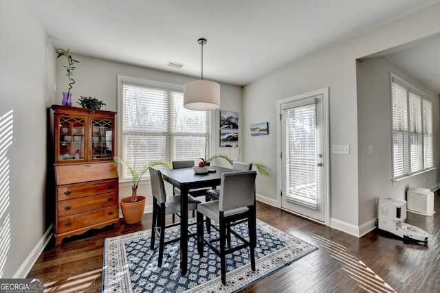 dining space featuring dark wood-style flooring, baseboards, and visible vents
