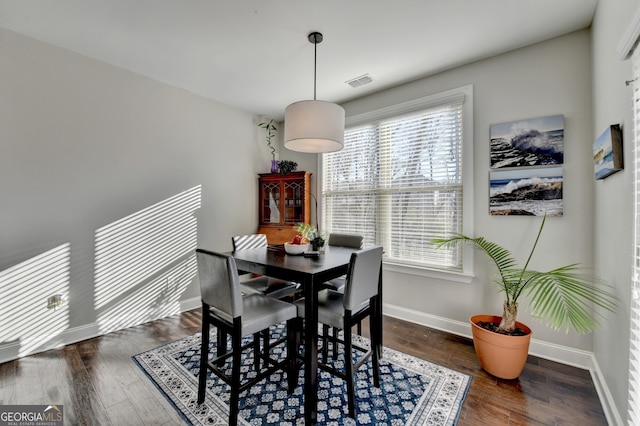 dining area featuring visible vents, a healthy amount of sunlight, baseboards, and wood finished floors