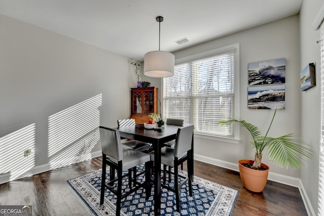 dining area with a wealth of natural light, visible vents, wood finished floors, and baseboards