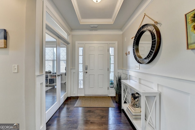 entrance foyer featuring visible vents, crown molding, dark wood finished floors, a wainscoted wall, and a tray ceiling