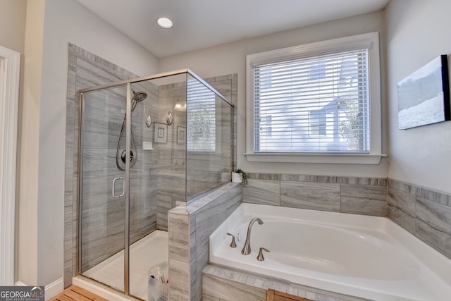 full bathroom featuring a garden tub and a shower stall