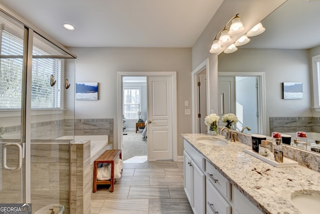 bathroom with double vanity, recessed lighting, a sink, a shower stall, and a bath