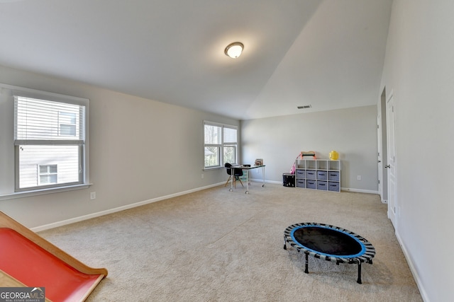 interior space with baseboards, vaulted ceiling, visible vents, and carpet floors