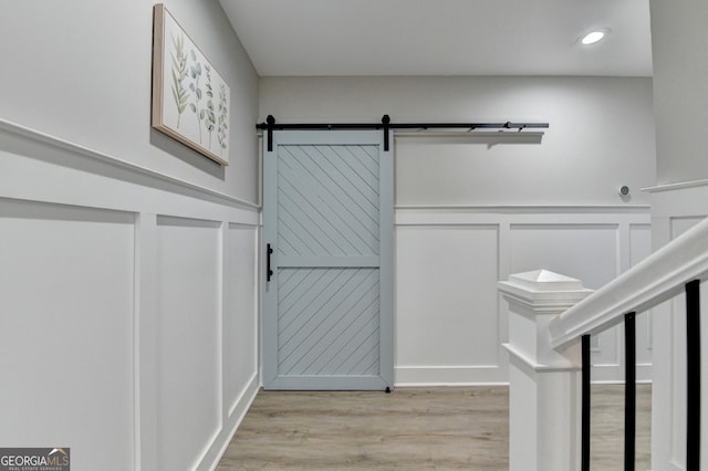 interior space with a barn door and light wood-style flooring