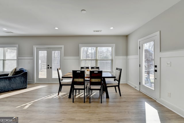 dining space featuring visible vents, plenty of natural light, french doors, and light wood-style flooring