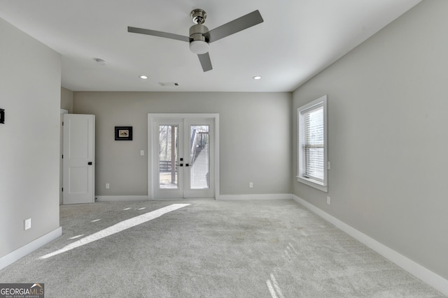 spare room featuring carpet flooring, french doors, visible vents, and baseboards