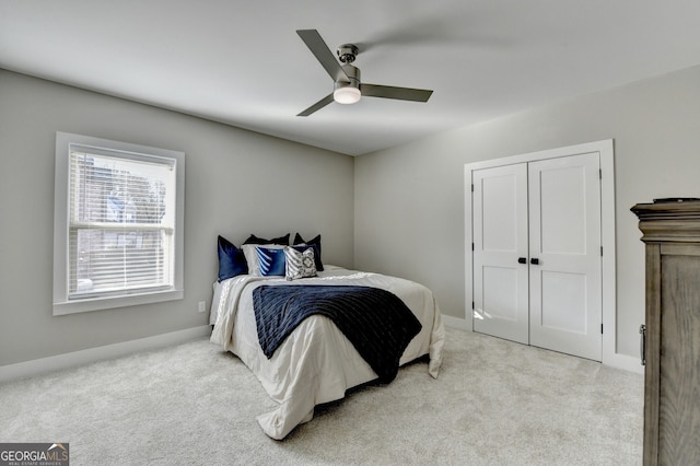 bedroom with a closet, baseboards, ceiling fan, and carpet floors