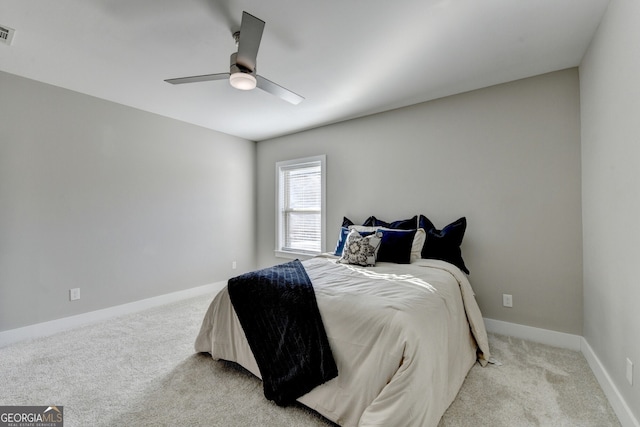 bedroom with baseboards, ceiling fan, visible vents, and light carpet