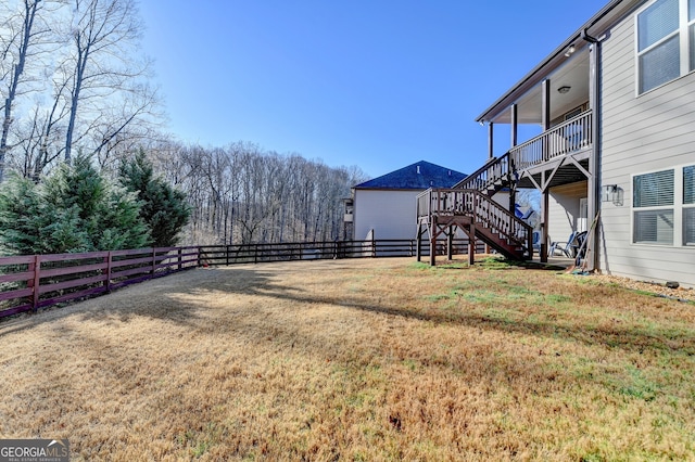 view of yard featuring stairway and fence