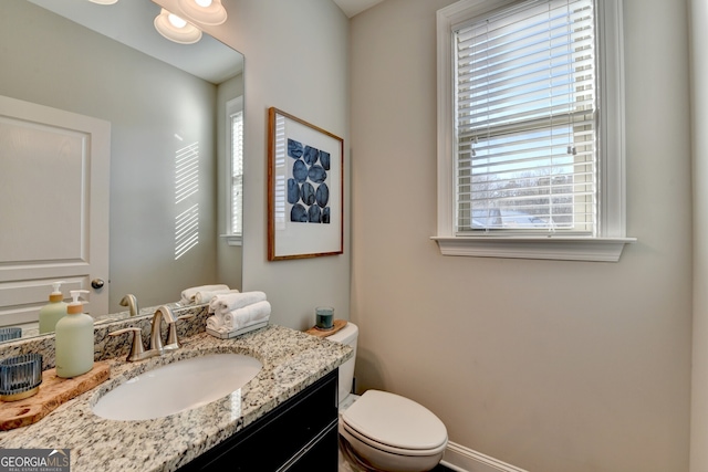bathroom with a wealth of natural light, toilet, and vanity