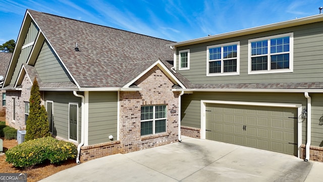 view of front of house with brick siding, driveway, an attached garage, and a shingled roof