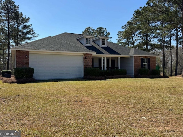 view of front of house featuring a front lawn, an attached garage, brick siding, and roof with shingles