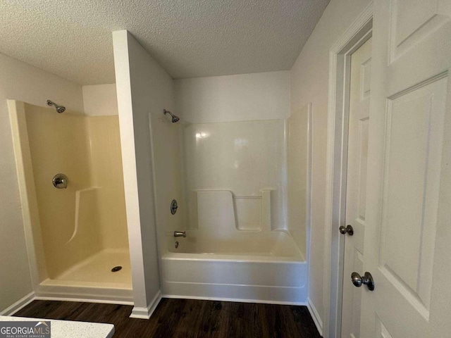 bathroom featuring a textured ceiling, baseboards, and wood finished floors