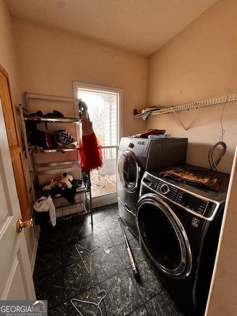 laundry area with laundry area, washing machine and dryer, and a textured ceiling