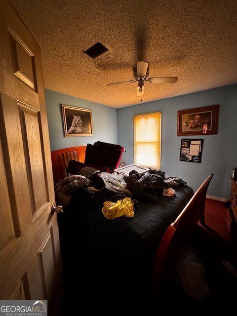 bedroom featuring visible vents, a textured ceiling, and ceiling fan