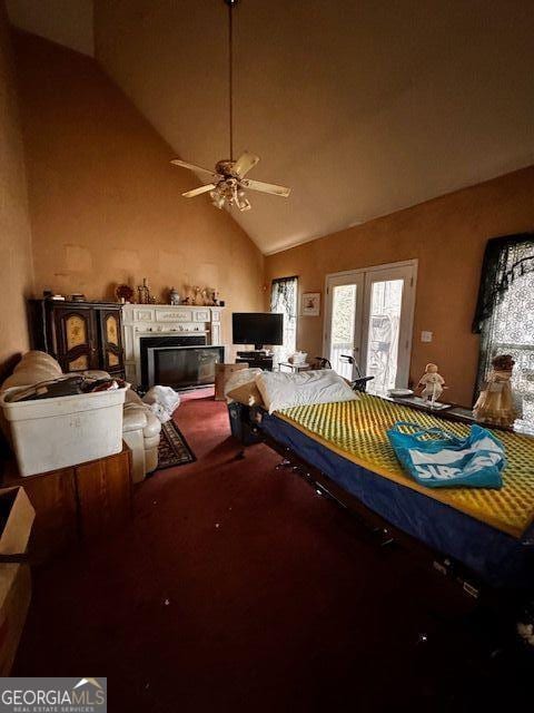 carpeted bedroom featuring a glass covered fireplace, access to exterior, french doors, and high vaulted ceiling