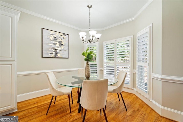 dining room featuring light wood-style flooring, ornamental molding, baseboards, and a notable chandelier