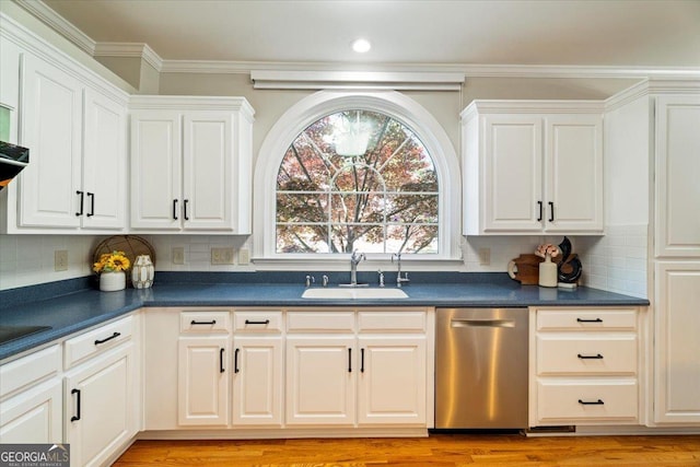 kitchen featuring dark countertops, dishwasher, decorative backsplash, and a sink