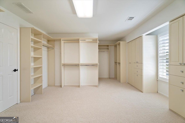 walk in closet with visible vents and light carpet