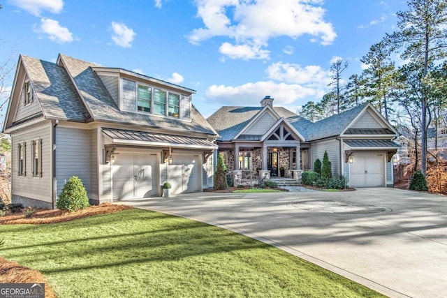 view of front of property with a shingled roof, a front lawn, concrete driveway, a garage, and a standing seam roof