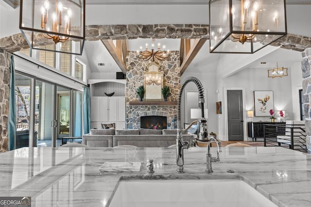 interior space with visible vents, an inviting chandelier, a towering ceiling, and a fireplace
