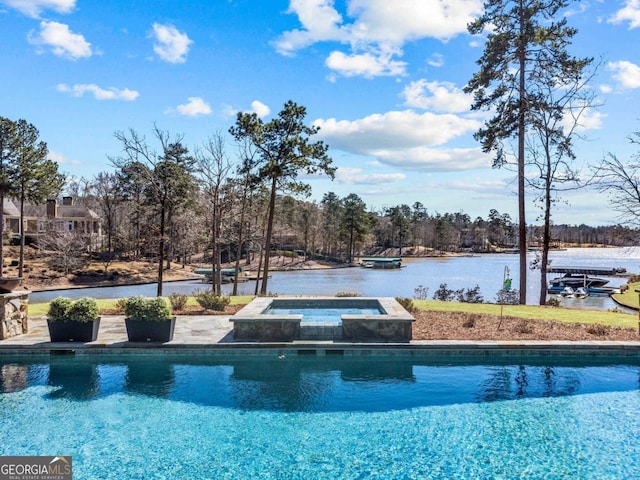 outdoor pool featuring a water view and an in ground hot tub