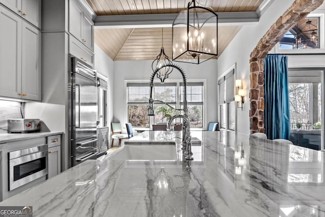 kitchen with a wealth of natural light, built in appliances, gray cabinetry, and wood ceiling