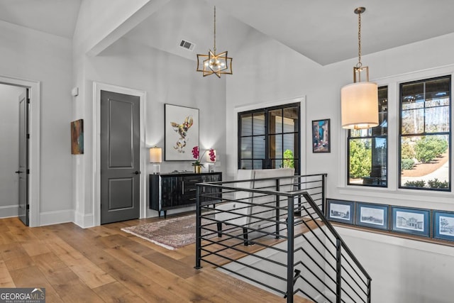 dining area featuring visible vents, plenty of natural light, an inviting chandelier, and hardwood / wood-style floors