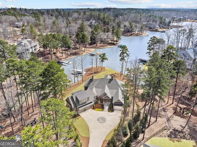 aerial view with a forest view and a water view