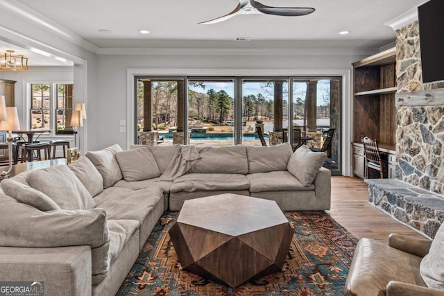 living room featuring a fireplace, wood finished floors, a wealth of natural light, and ceiling fan