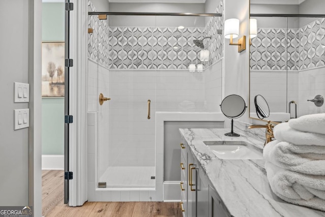 bathroom featuring vanity, a shower stall, and wood finished floors
