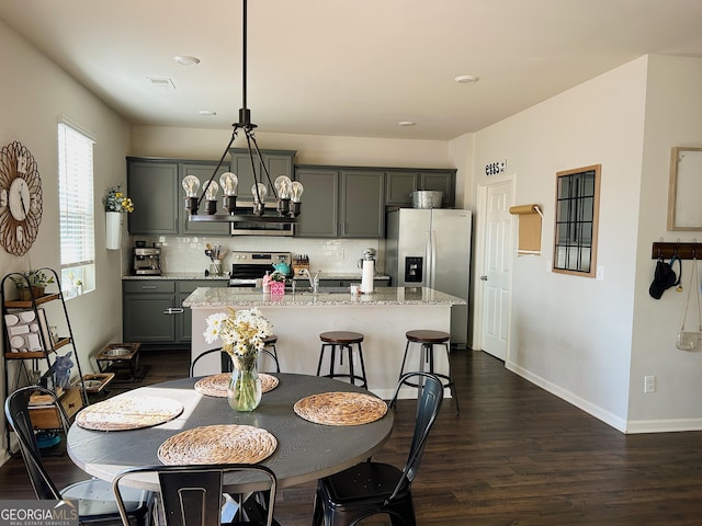 dining room with visible vents, baseboards, a notable chandelier, and dark wood-style floors