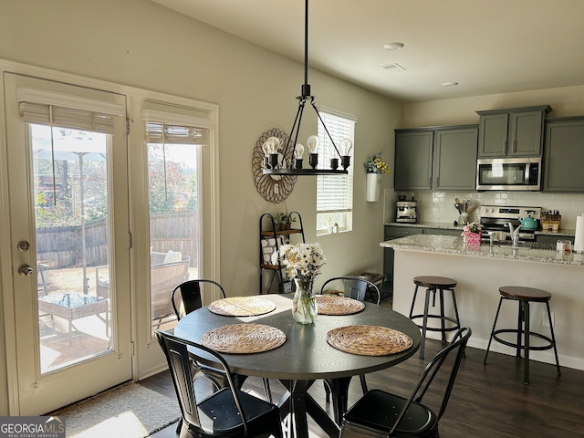 dining area with dark wood finished floors, an inviting chandelier, and visible vents