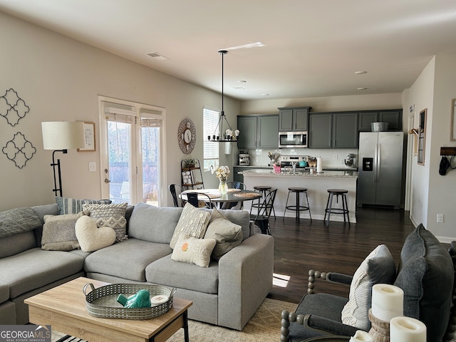 living room featuring visible vents and dark wood finished floors