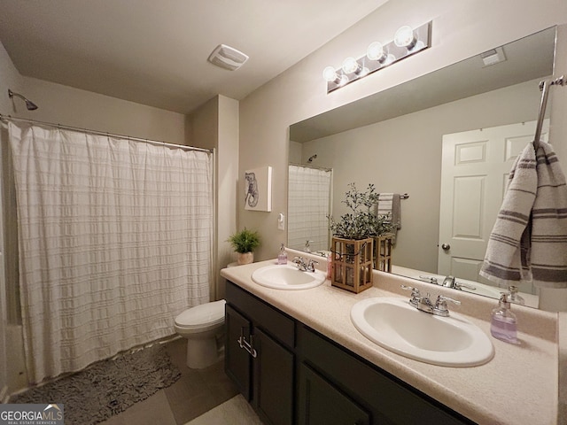 bathroom with double vanity, toilet, visible vents, and a sink