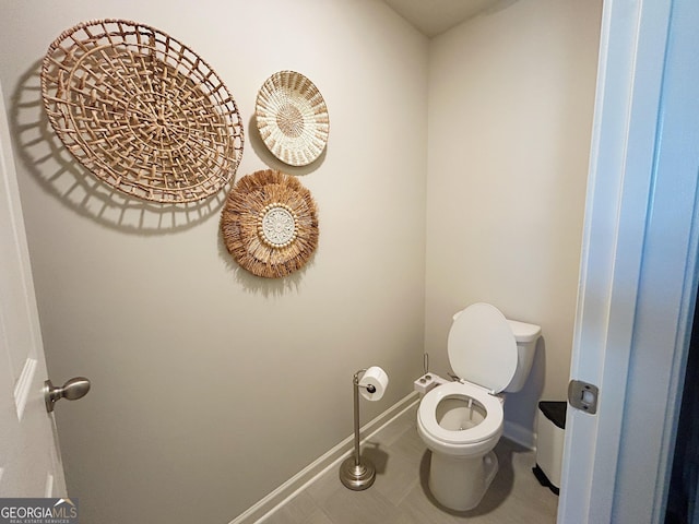 bathroom with tile patterned floors, baseboards, and toilet