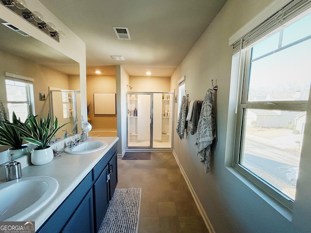 full bathroom with baseboards, visible vents, a stall shower, and a sink