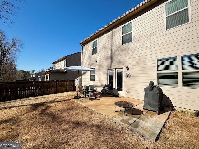 back of property featuring a patio area, fence, and an outdoor fire pit