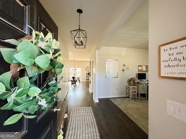 entrance foyer with a notable chandelier, wood finished floors, and baseboards