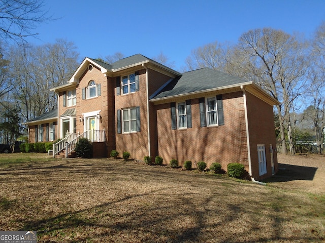 view of front of property featuring brick siding and a front yard