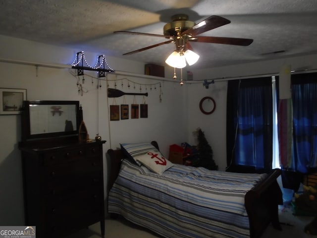 bedroom featuring visible vents, a textured ceiling, and a ceiling fan