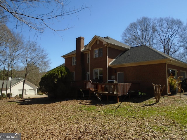 back of house with a wooden deck, brick siding, and a chimney